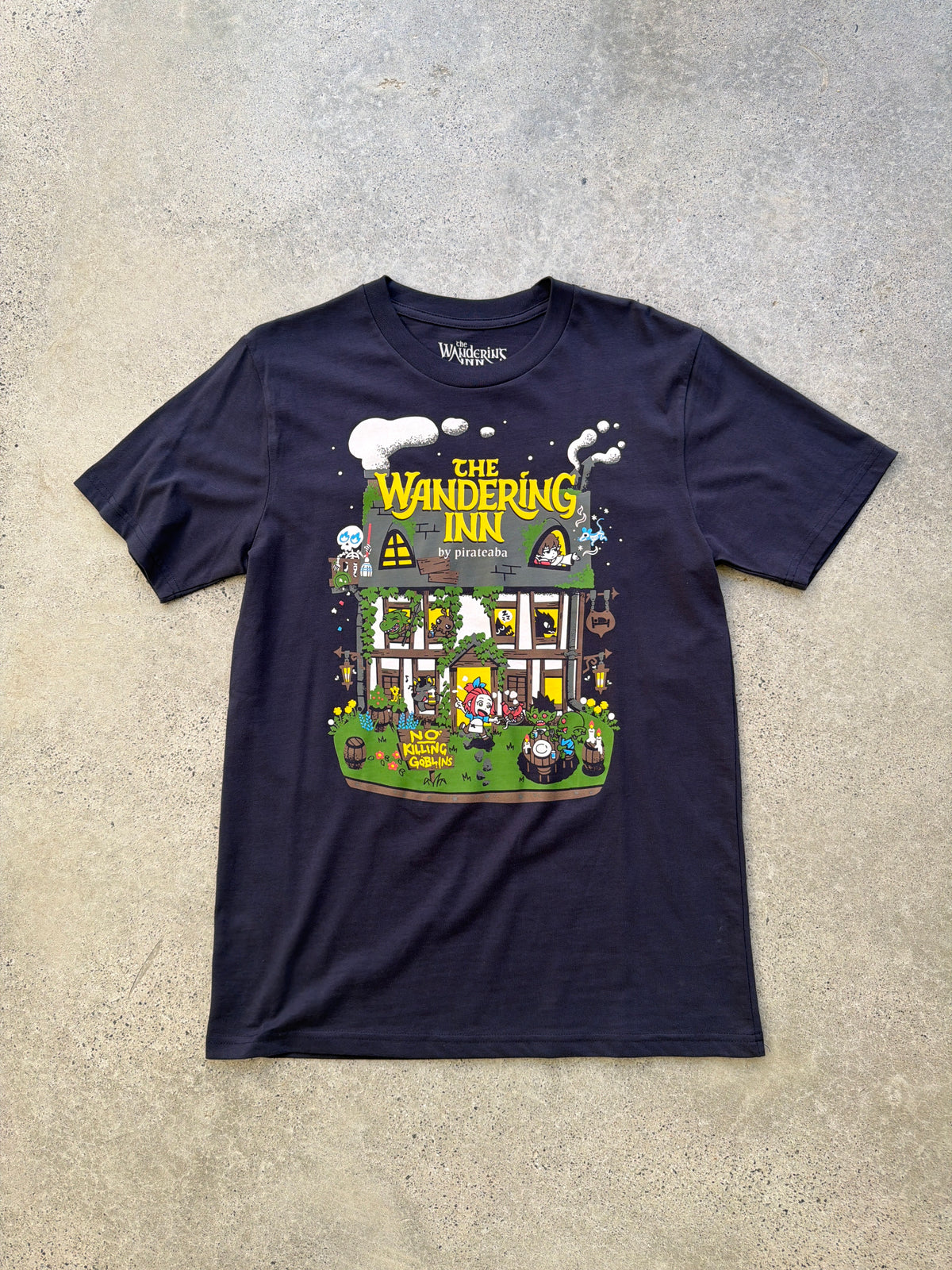 The real tee laid on concrete, full print and printed neck label