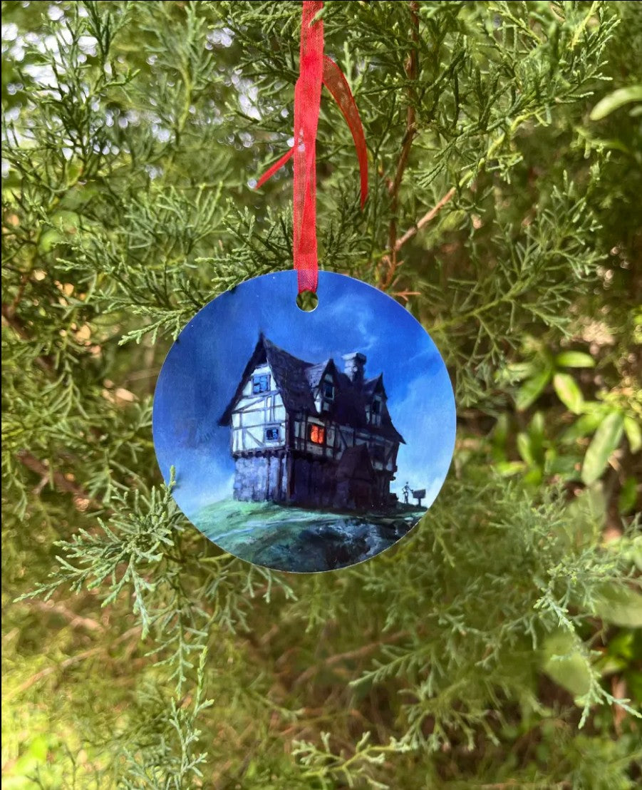 The Wandering Inn Christmas ornament hanging on a tree, showing the illustrated inn artwork