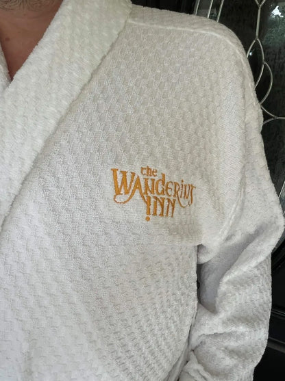 Close view of the gold embroidered logo on The Wandering Inn bathrobe