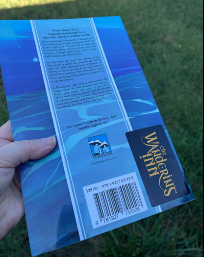 Back cover of The Last Tide softcover, held outdoors: the story blurb, the Cloudscape Comics logo, The Wandering Inn logo, and the barcode showing ISBN 978-1-927742-22-8