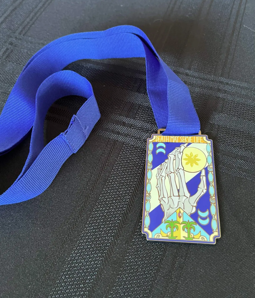 Khelt medallion on its blue ribbon, lying on a dark cloth