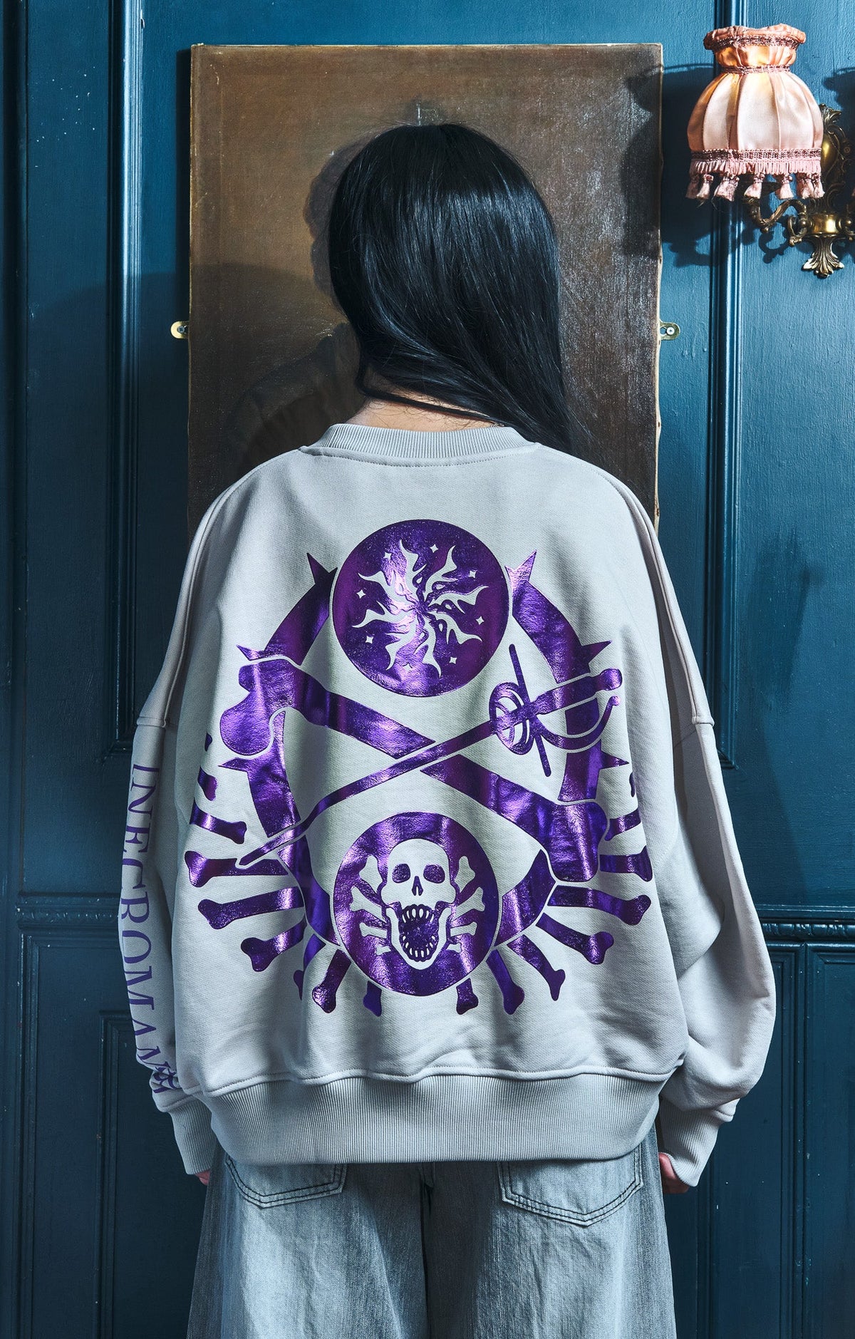 Back of the gray sweatshirt with the purple foil skull crest. The Wandering Inn merch by pirateaba